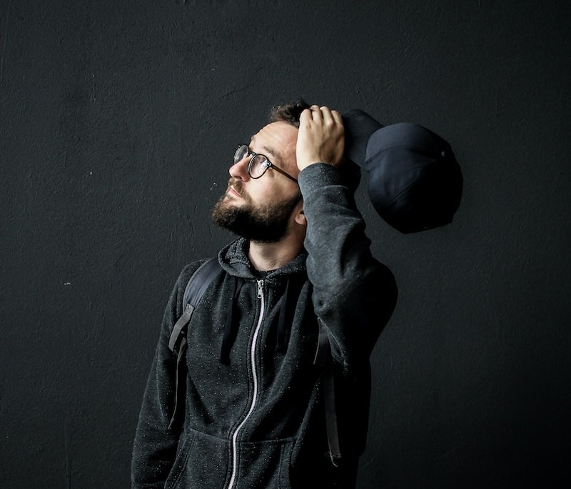 man looking up holding his hair