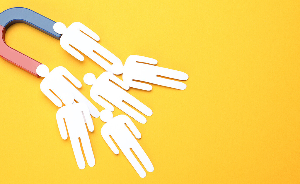Een gigantische magneet die verschillende witte uitgesneden figuren op een felgele achtergrond aantrekt, wat de naadloze aantrekkingskracht van dynamische remarketing symboliseert.