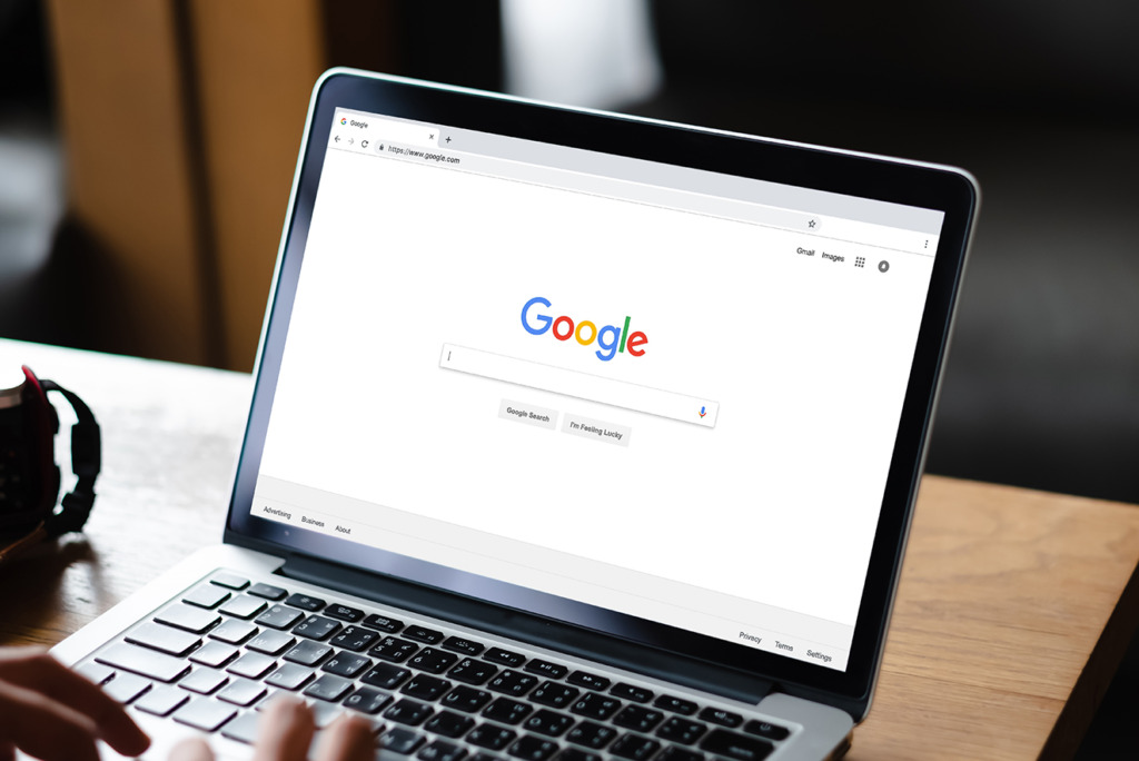 Een persoon die op een laptop typt terwijl de startpagina van Google Zoeken op het scherm geopend is en mogelijk tips voor online advertenties opzoekt.