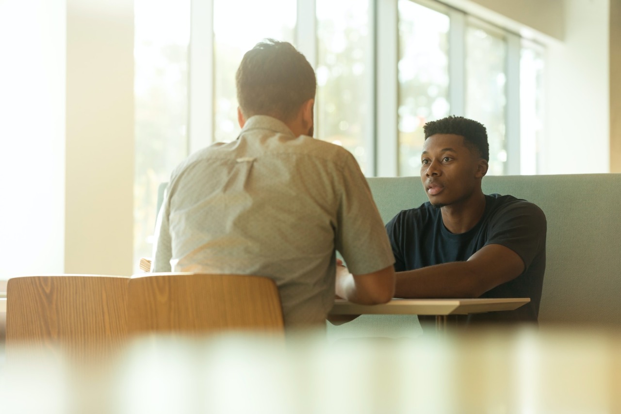 Gesprek van twee mannen die feedback geven op elkaars functioneren