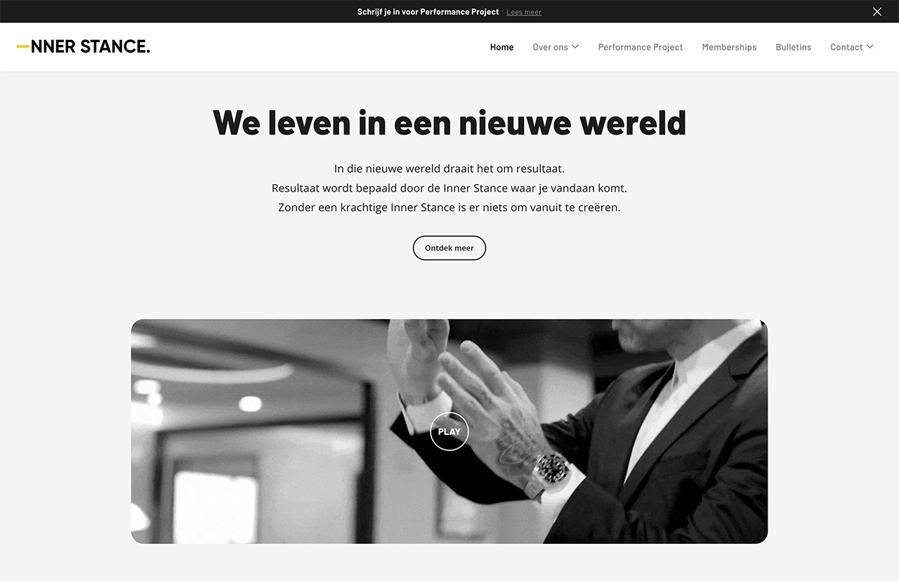 Websitescreenshot met Nederlandse tekst "We leven in een nieuwe wereld" en een grijswaardenafbeelding van een persoon in pak, die een innerlijke houding weerspiegelt.