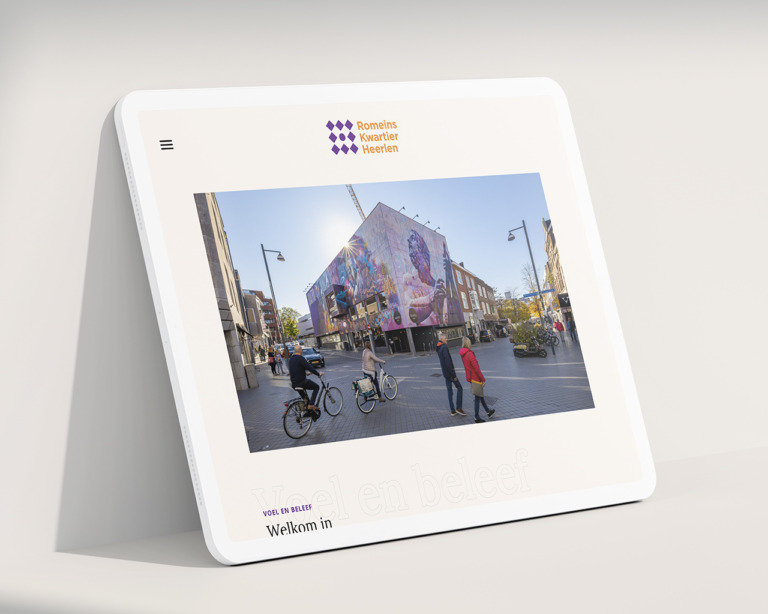 Tablet met een muurschildering uit het Heerlense Romeins Kwartier op het scherm, geplaatst op een wit oppervlak met een zachte schaduw.