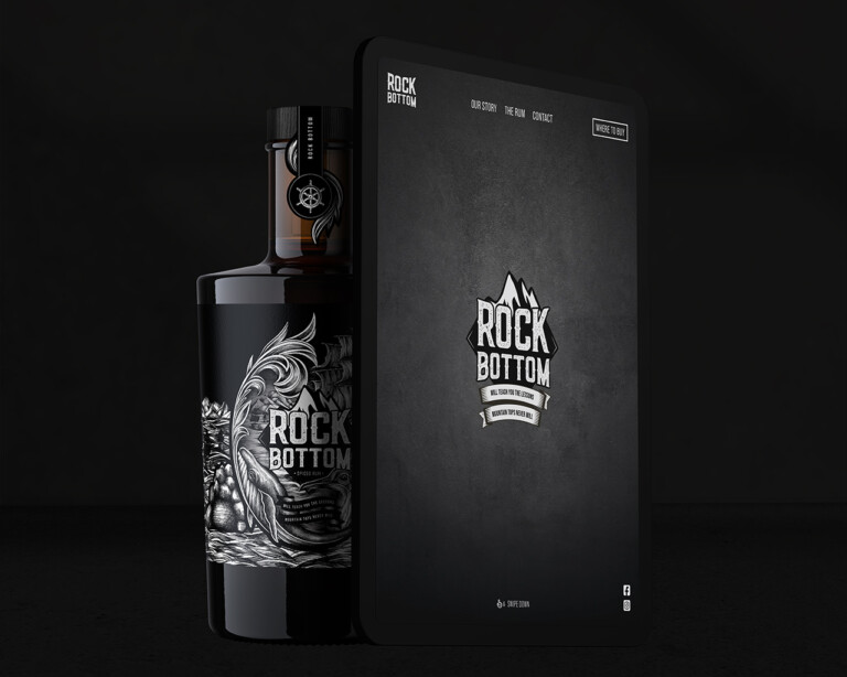 Een fles met een donker thema en een rechthoekige doos naast elkaar, beide met het opschrift "Rock Bottom Spirits" met ingewikkelde ontwerpen.