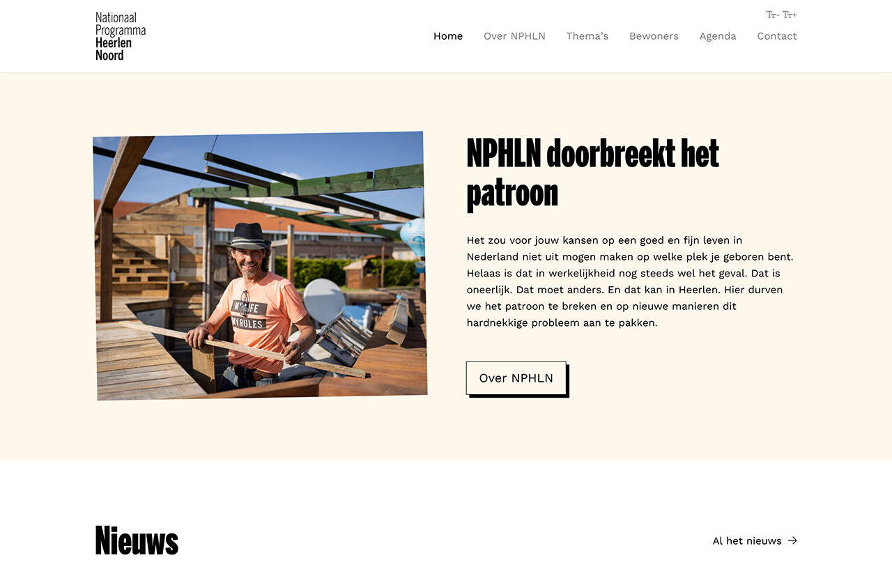 Een man met hoed bouwt op een zonnige dag buiten een houten constructie, met naast hem een Nederlandse tekst over het Nationaal Programma Heerlen-Noord.
