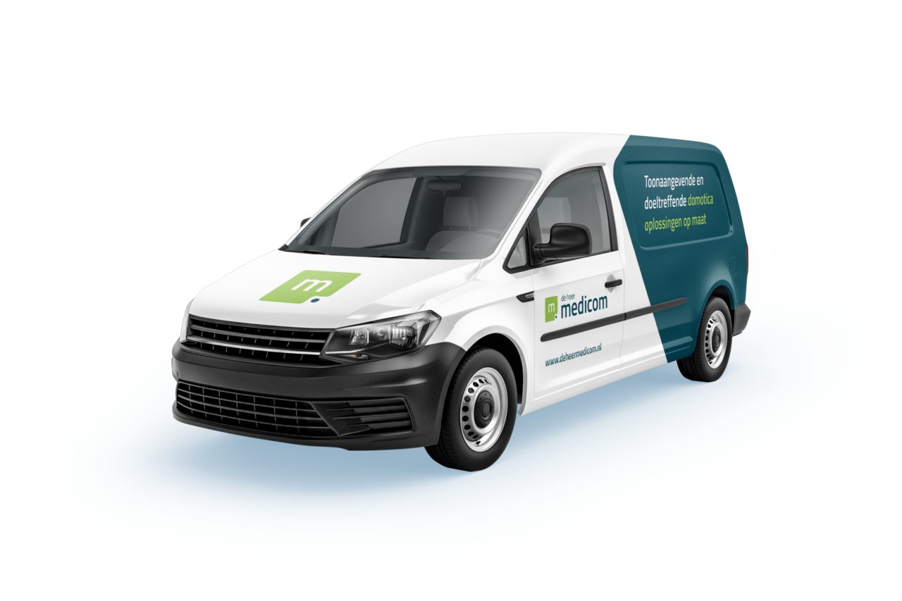 Wit-groene Medicom bestelwagen met reclametekst De Heer Medicom op zij- en vooraanzicht.