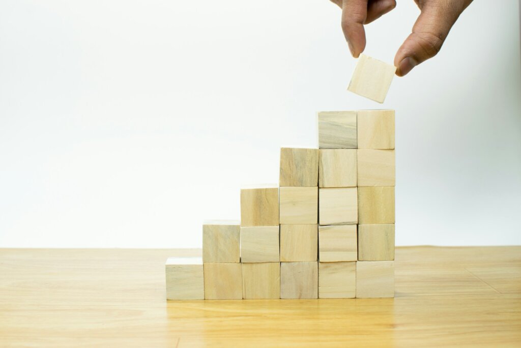 A person placing a piece of wood into a pyramid