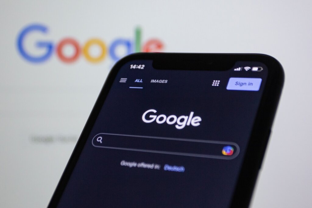 a close up of a cell phone with the google logo in the background