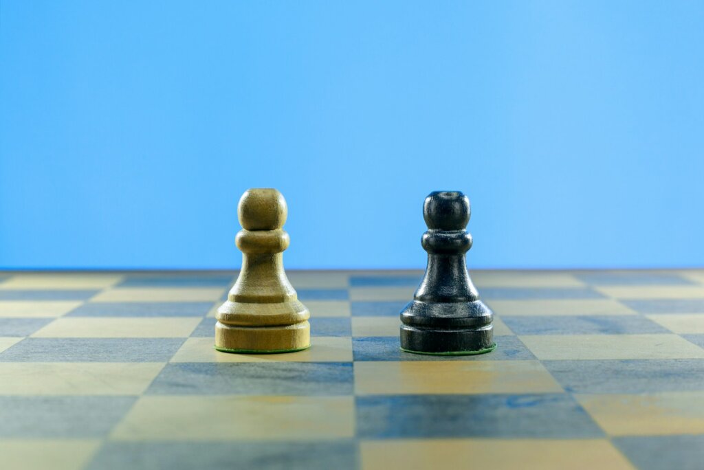 a black and a white chess piece on a checkered board
