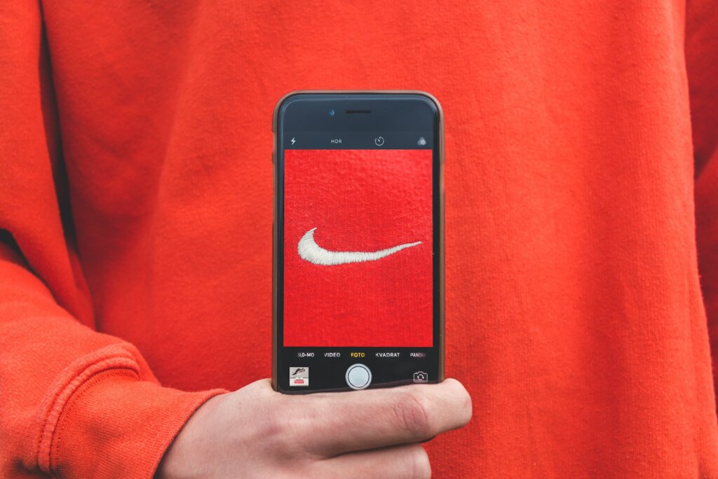 person holding iPhone taking picture on Nike label