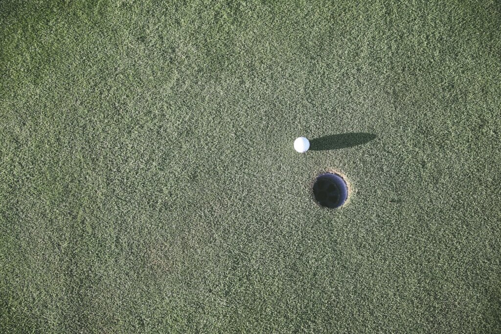 white golf ball near hole