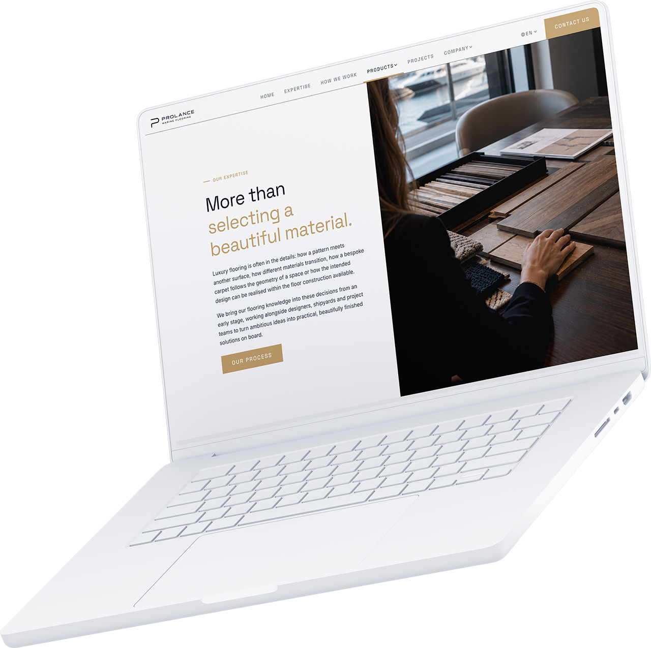Op een witte laptop wordt een website over het kiezen van materialen weergegeven, waarop te zien is hoe iemand houtmonsters bekijkt.